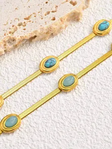 Dettaglio della catena a serpente dorata con intarsi ovali in pietra di turchese