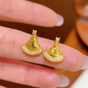 Close-up of fan-shaped stud earrings with gold plating and sparkling crystal accents