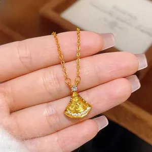Detail shot of a fan-shaped gold pendant with sparkling diamonds on a delicate chain