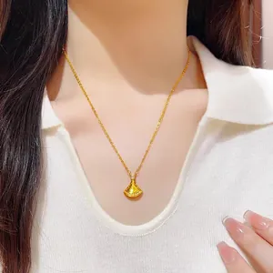 Detailed view of a gold fan-shaped necklace with diamond accents worn on a neck