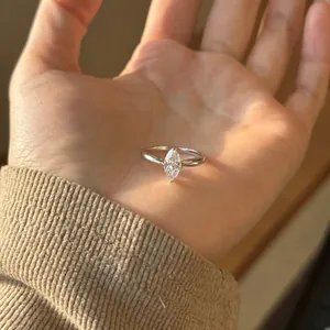 Close-up of a marquise-cut white zircon ring in silver finish held in hand