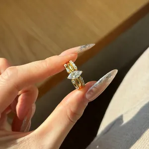 Detailed close-up of marquise-cut gold rings with micro-pave diamonds on hand