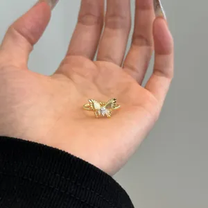 Gedetailleerde weergave van een gouden vlinderring met marquise-zirkon in de hand