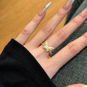 Detailopname van een gouden vlinderring met marquise zirkoon en een gedraaide ringband