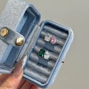 Détail de bagues en argent S925 avec zircons taille émeraude et poire en écrin bleu