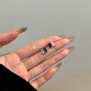 Détail de boucles d'oreilles en argent avec pierre verte rectangulaire et zircon goutte