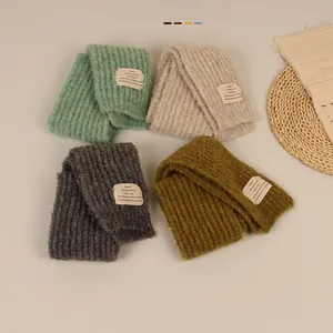 Detailed close-up of chunky knit scarves showing soft texture and woven label details