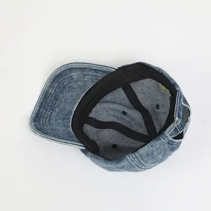 Macro shot of washed blue denim cap interior with adjustable buckle and smile label