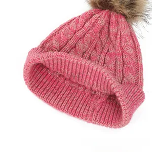 Close-up of thick knit pattern and wide ribbed cuff on a bicolor winter pompom hat