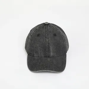 Detail of dark grey washed denim baseball cap showing fabric texture and seams