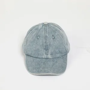 Detail of light blue washed denim baseball cap featuring breathable vents and curved brim