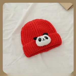 Gros plan du bonnet tricoté rouge pour enfants avec motif panda mignon en relief
