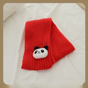 Détail d'une écharpe en tricot rouge pour enfants avec mascotte panda et texture épaisse