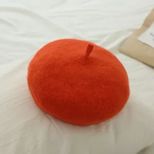 Close-up of a classic red wool beret for girls with soft wool felt texture and stem detail