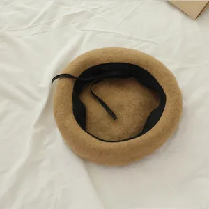 Detail view of camel wool beret showing inner black sweatband and adjustable drawstring