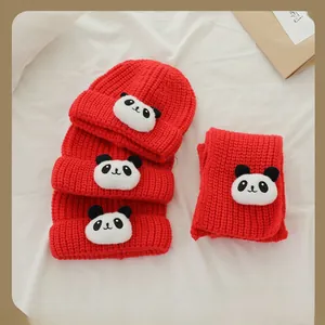 Détail de l'ensemble bonnet et écharpe rouge en tricot avec motif de panda mignon épais