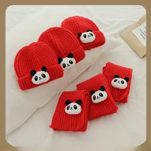 Gros plan d'un ensemble bonnet et écharpe en maille rouge avec écusson panda