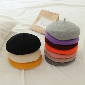 Detailed close-up of wool felt beret hats in various colors with classic top stem