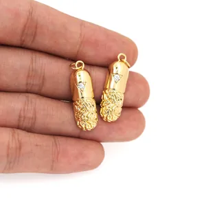 Detalle del colgante de cápsula bañada en oro con circonita de corazón y textura grabada