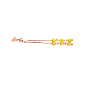 Détail d'un bracelet coulissant en or rose avec cristaux jaunes et chaîne ajustable