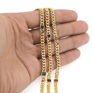 Λεπτομέρεια από επιχρυσωμένο βραχιόλι 18K με πέτρες ζιργκόν σε σχήμα καρδιάς και σμαράγδι