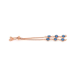 Détail macro du bracelet réglable en or rose avec six pierres de zircone bleu foncé