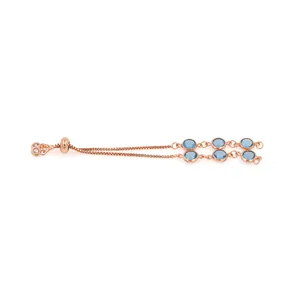 Détail d'un bracelet en or rose avec doubles chaînes, six cristaux bleus et fermoir réglable