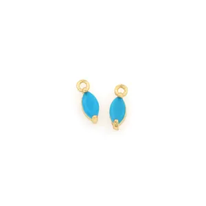 Macro detail of turquoise marquise charms with 18K gold plated trim and zircon inlay