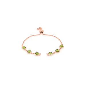 Détail du bracelet en or rose avec pierres vertes et fermoir coulissant ajustable