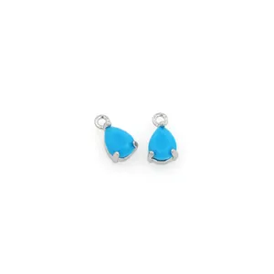 Detail of tear-drop shaped light blue gemstone pendant with 18K gold plated silver setting