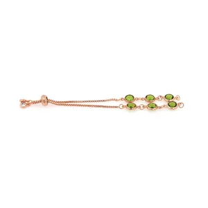 Détail du bracelet réglable en or rose avec gemmes vertes et oxydes de zirconium