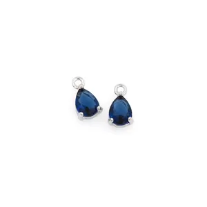 Macro detail of deep blue pear-cut zircon pendants with silver three-prong settings