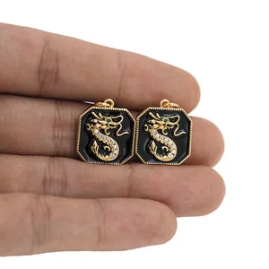 Detailed macro view of gold plated dragon pendants with black enamel and zircon inlay