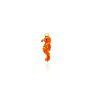 Détail macro d'un pendentif hippocampe orange vif plaqué or 18 carats avec résine