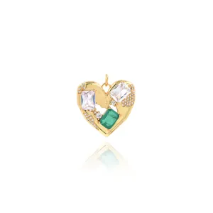 Détail macro d'un pendentif coeur en or avec pierre vert émeraude et zircon