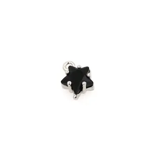 Detail shot of a black star-shaped pendant with a silver metal base and a mounting ring