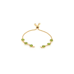 Detailed view of 18K gold plated bolo bracelet with adjustable slide and green stones