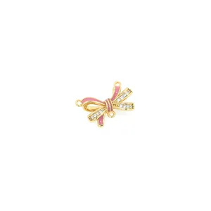 Detailed view of pink enamel bow pendant with zircon accents and 18K gold plated finish