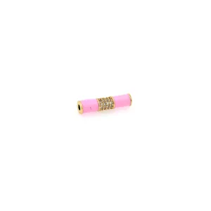 Dettaglio macro della perla a tubo in bambù placcata oro 18K con smalto rosa e zirconi