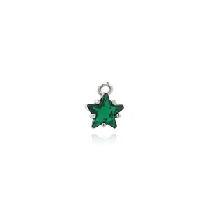 Macro detail of 18K gold plated star pendant with green zircon and silver base