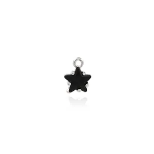 Macro detail of black star pendant with silver claw setting and top hanging loop