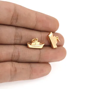 Detailopname van twee 18K vergulde bootbedeltjes voor het maken van DIY-sieraden