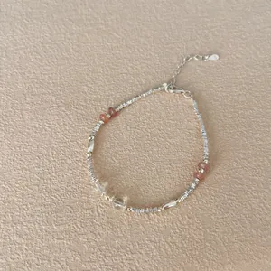 Macro detail of S925 sterling silver beaded bracelet with natural orange crystal beads