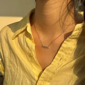 Primer plano del collar con colgante MAMA de plata de ley S925 en el cuello de una modelo