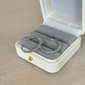 Detailed shot of S925 silver hoop earrings with pave cubic zirconia in a white gift box