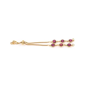 Detailed macro of 18K gold-plated slider bracelet with six circular deep purple gemstones