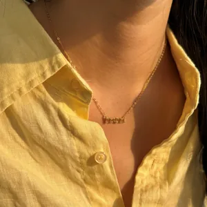 Élégant collier doré avec lettres MAMA et zircone sur un mannequin pour la fête des mères