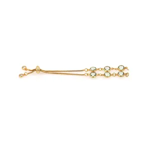 Detail of 18K gold-plated bolo bracelet featuring six bezel-set green crystals and slider