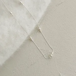Détail macro d'une chaîne en argent S925 avec pendentif élégant en grappe de perles