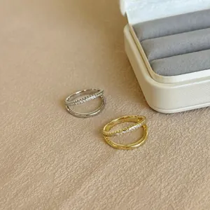 Macro detail of silver and gold double-layer rings with cubic zirconia inlay on a jewelry box